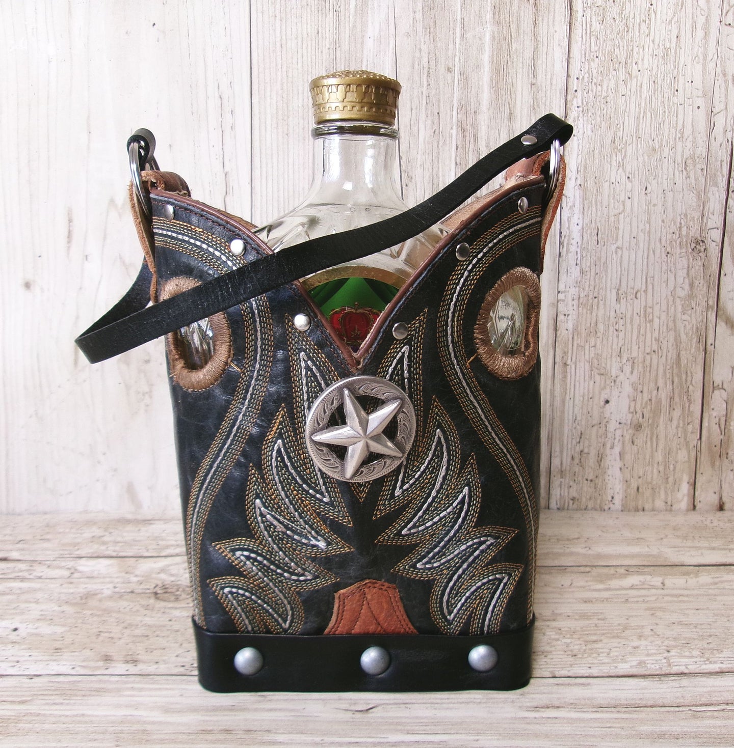 Cowboy boot-shaped bottle holder with star design on a wooden surface